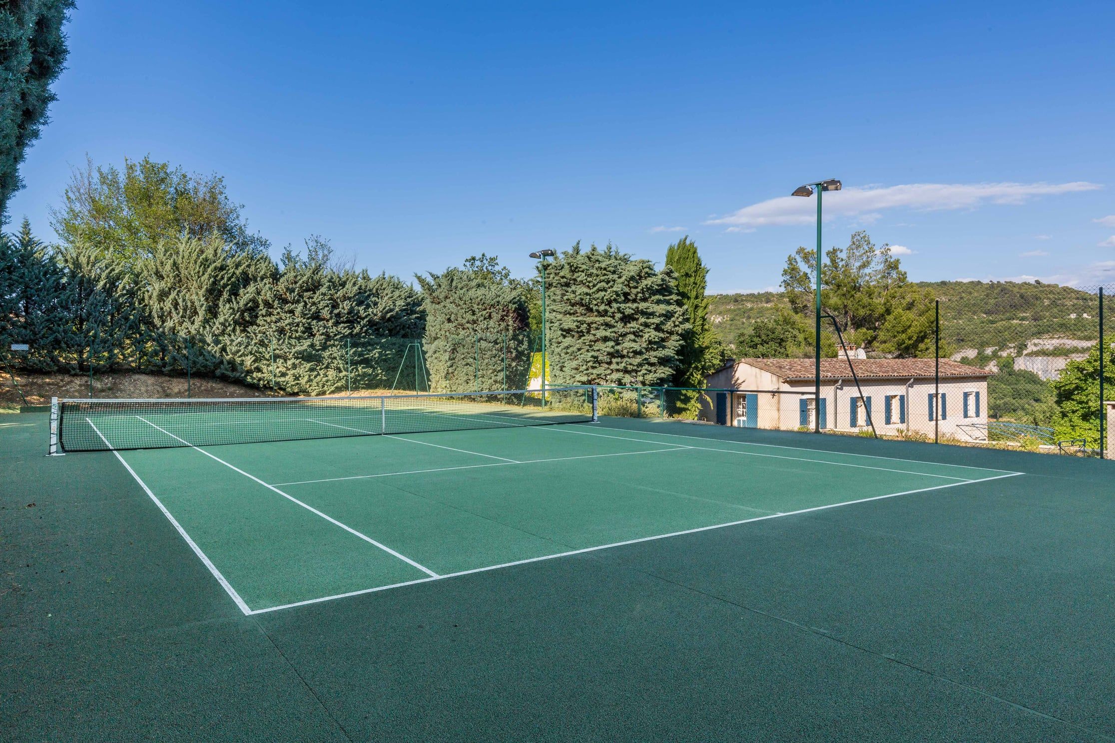 The floodlit hard tennis court in the grounds of La Source